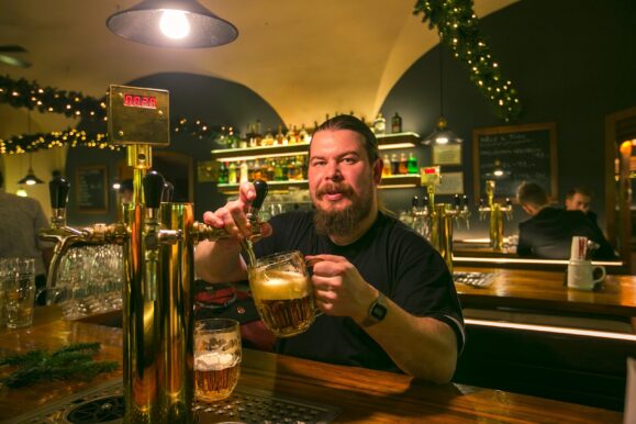 Бармен в Праге наливает пиво